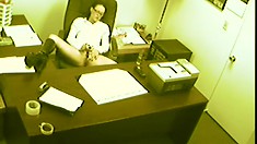 A security camera catches a lustful babe pleasing her hungry snatch in the office